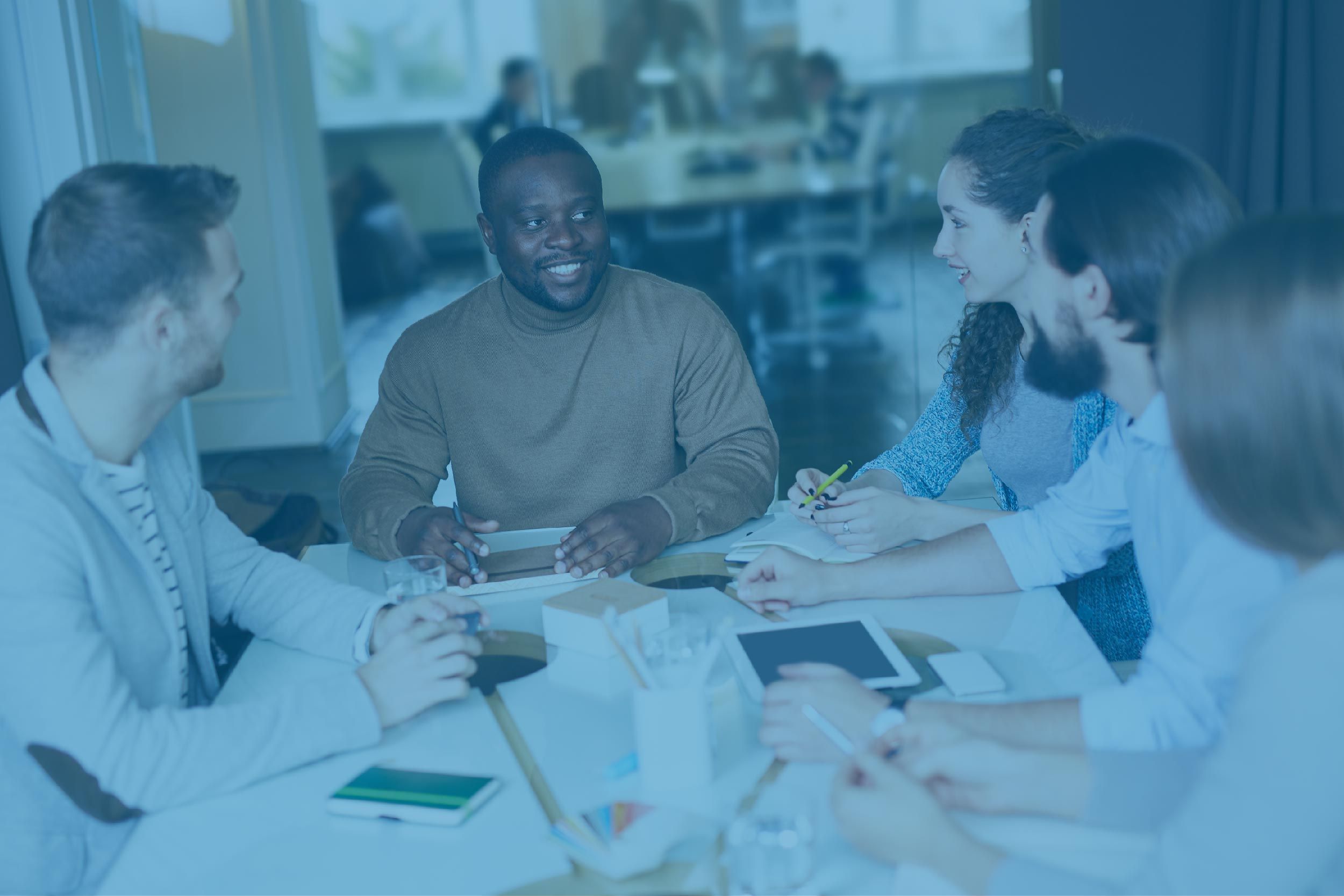 Des personnes assissent autour d'une table entrain de discuter